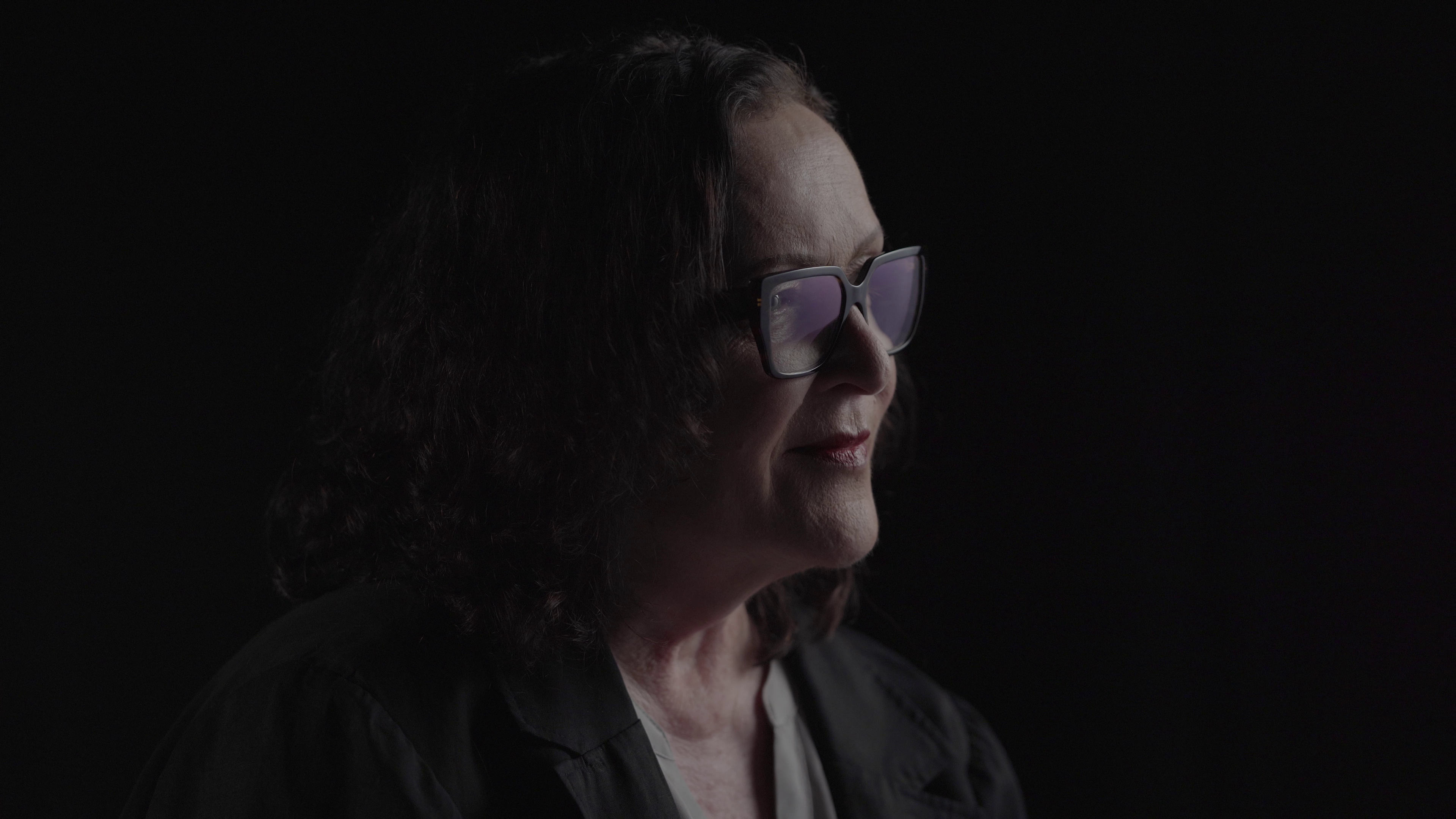A woman filmed in profile during a portrait interview